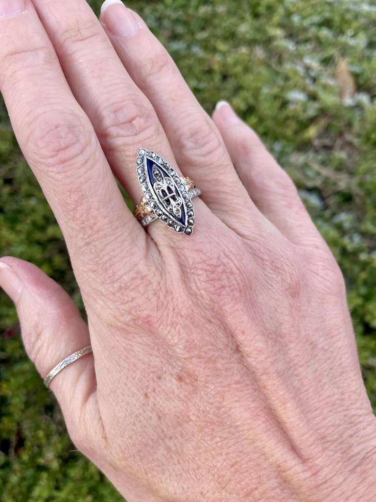 Bague ancienne de forme marquise avec anneau en or jaune 18 carats, plateau en argent serti de marcassites et médaillon central en émail bleu.
